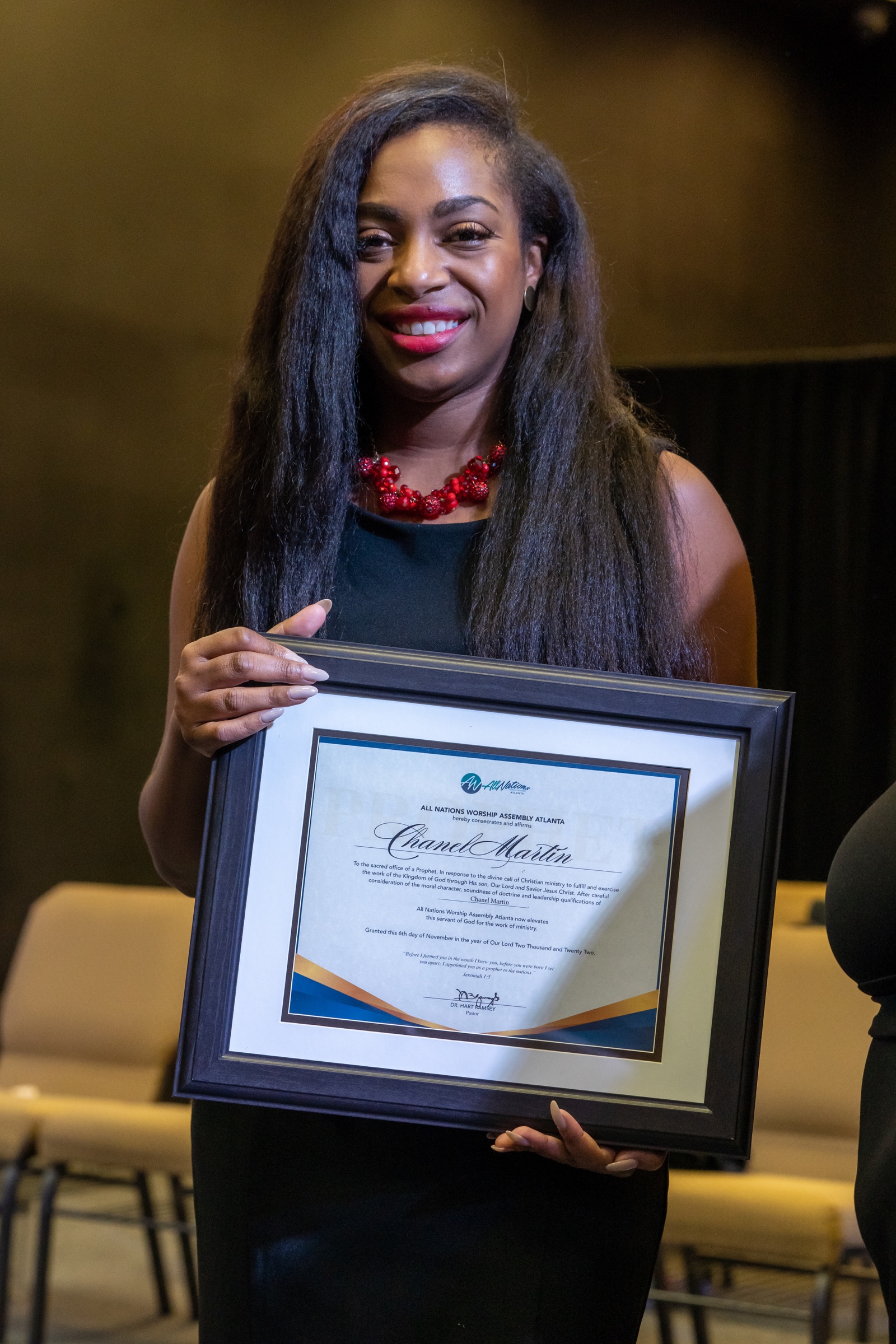 Chanel holding her framed ordination certificate