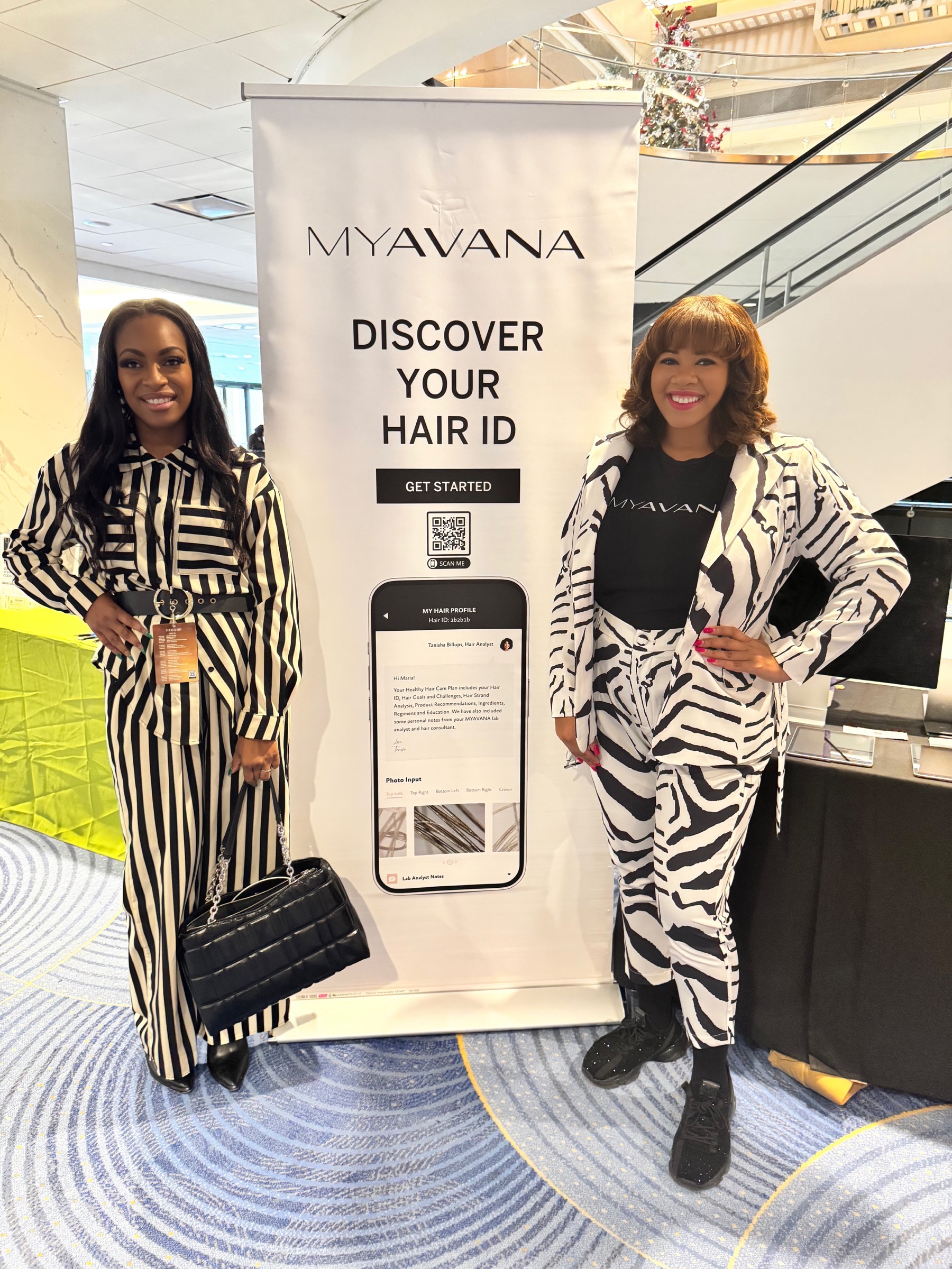 Chanel E. Martin and Candace Mitchell Harris beside a MYAVANA hair technology display